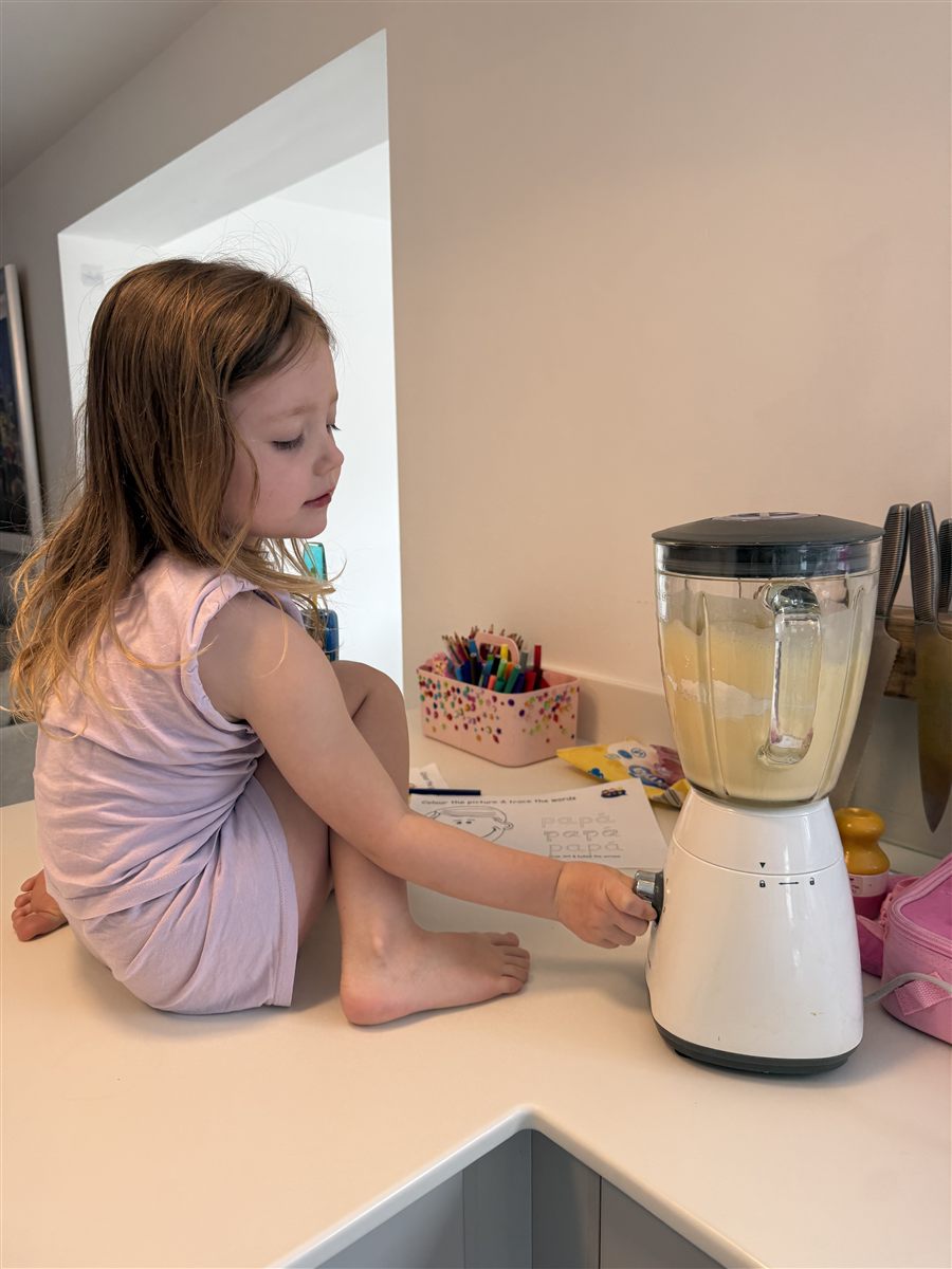 A child preparing food at a kitchen counter